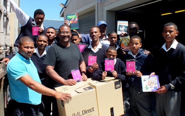 Die enorme vrag boeke wat deur Jack Doyle van Engeland per vragskip na Gansbaai PrimÃªr gestuur is, met Tommy Volkwyn (skoolhoof) direk agter een van die kartondose
